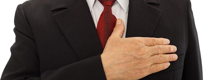 Man in pak met de hand op het hart